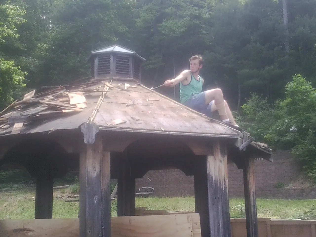 Tearing the old roof off a wooden gazebo before new shakes in Freedom