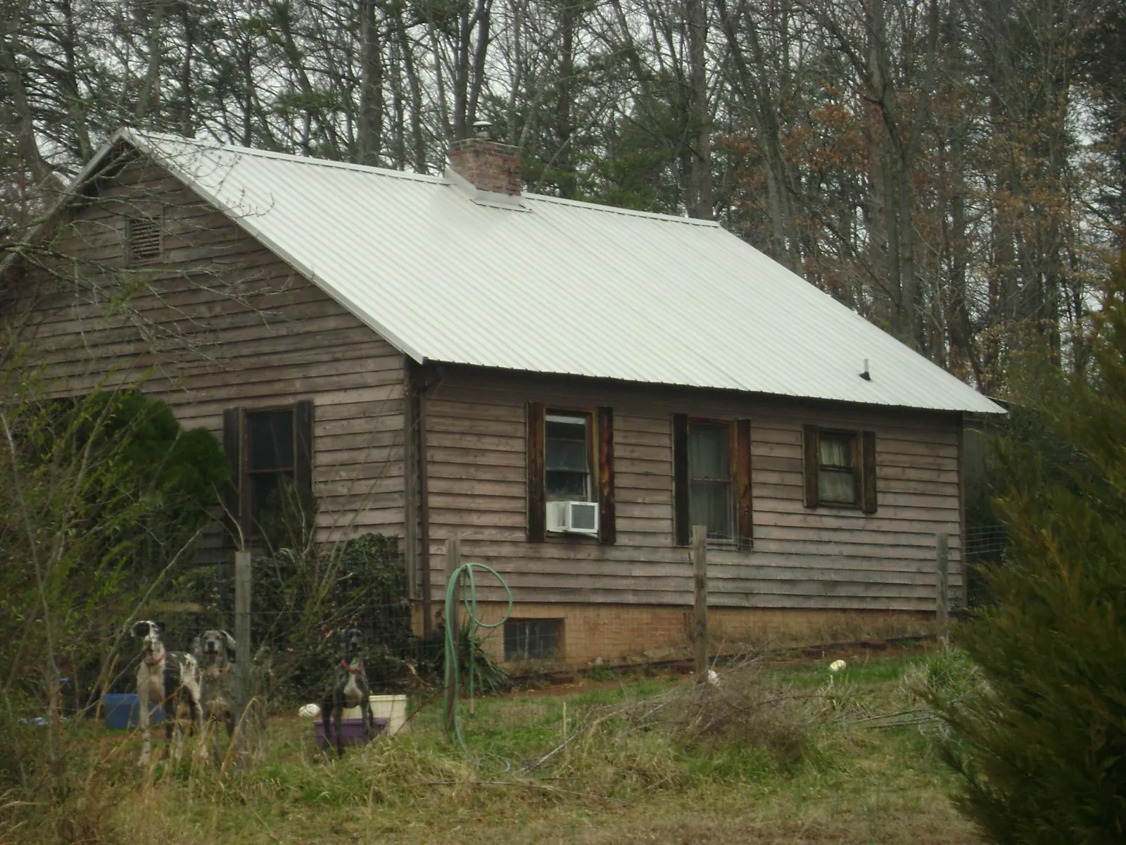 White metal roof on an old wood sided farmhouse, from a Metal Roof Installation job in Freedom